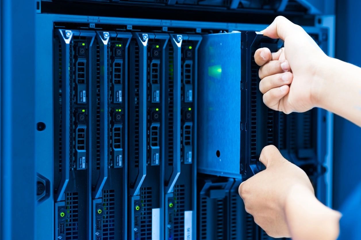 A person holding up their hands in front of some servers.