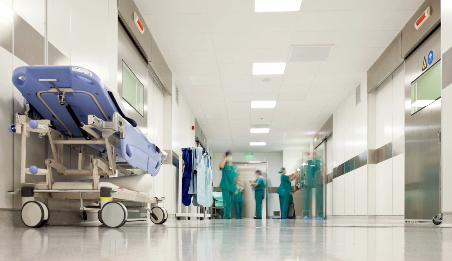 A hospital room with several doctors and nurses.