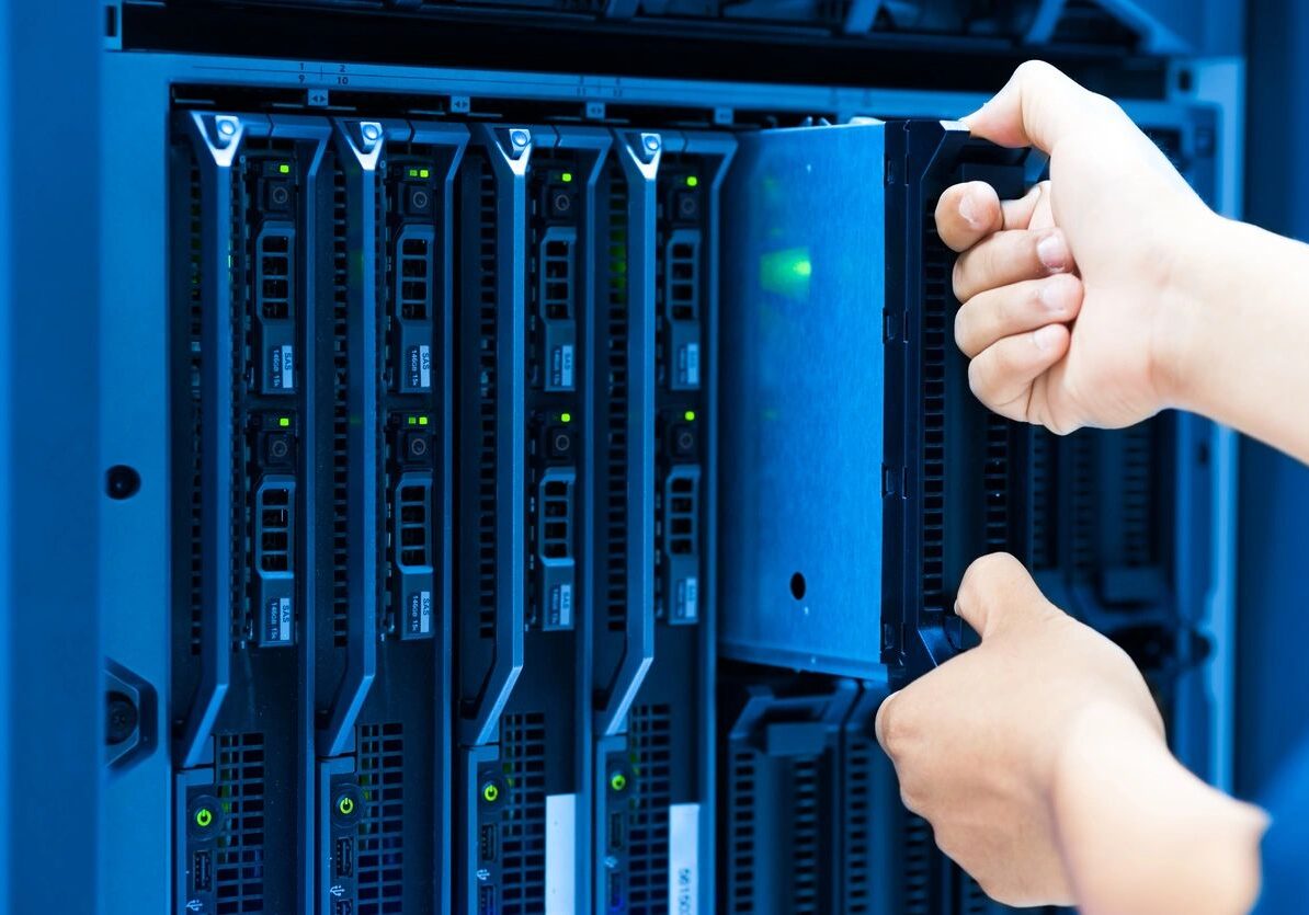 A person holding up their hands in front of some servers.